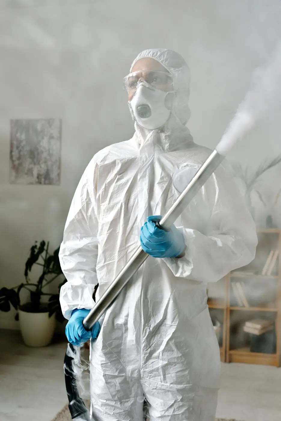 PCES technician in full protective suit carrying out pest control