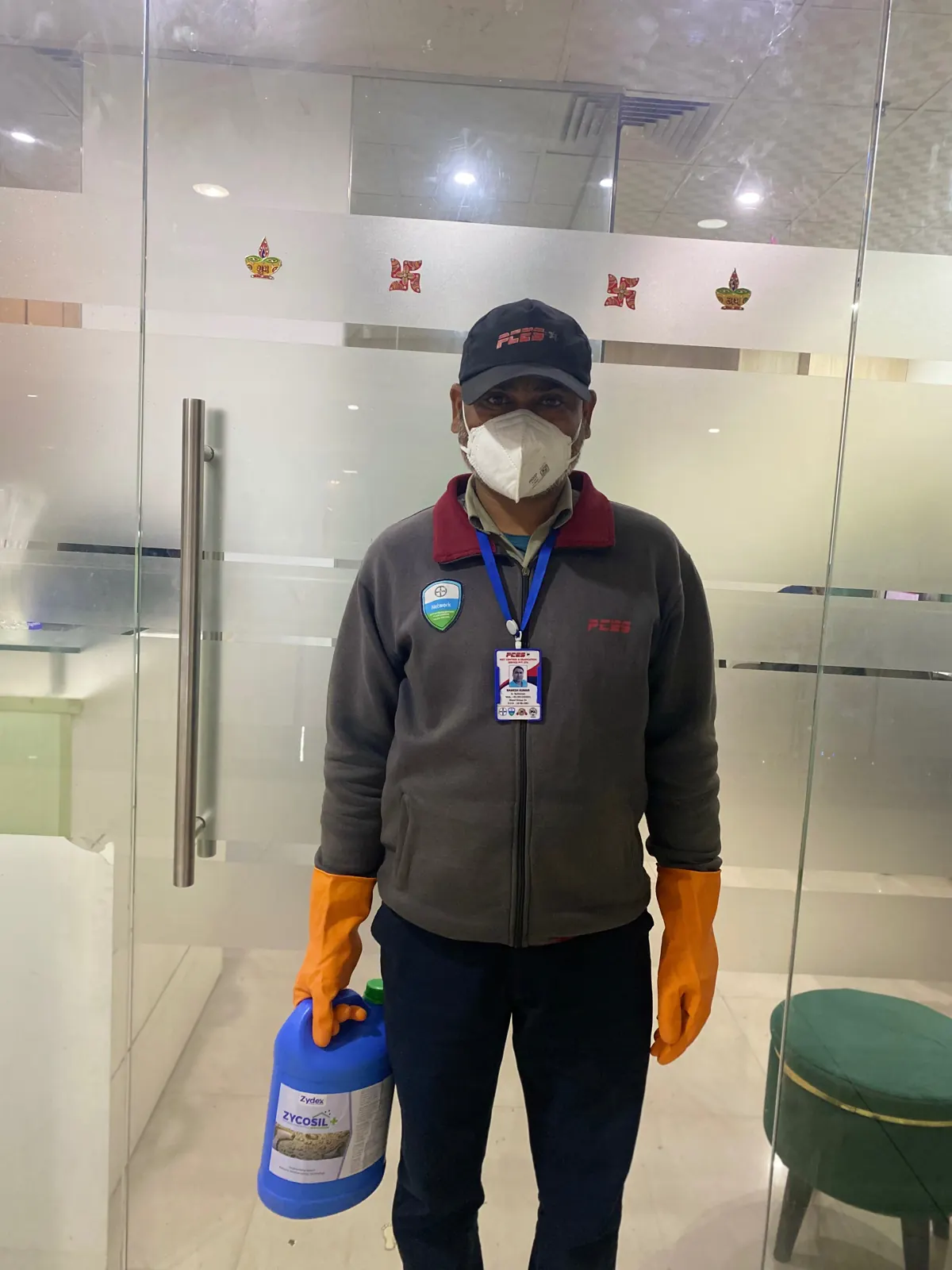 PCES technician in uniform with mask, gloves and photo ID