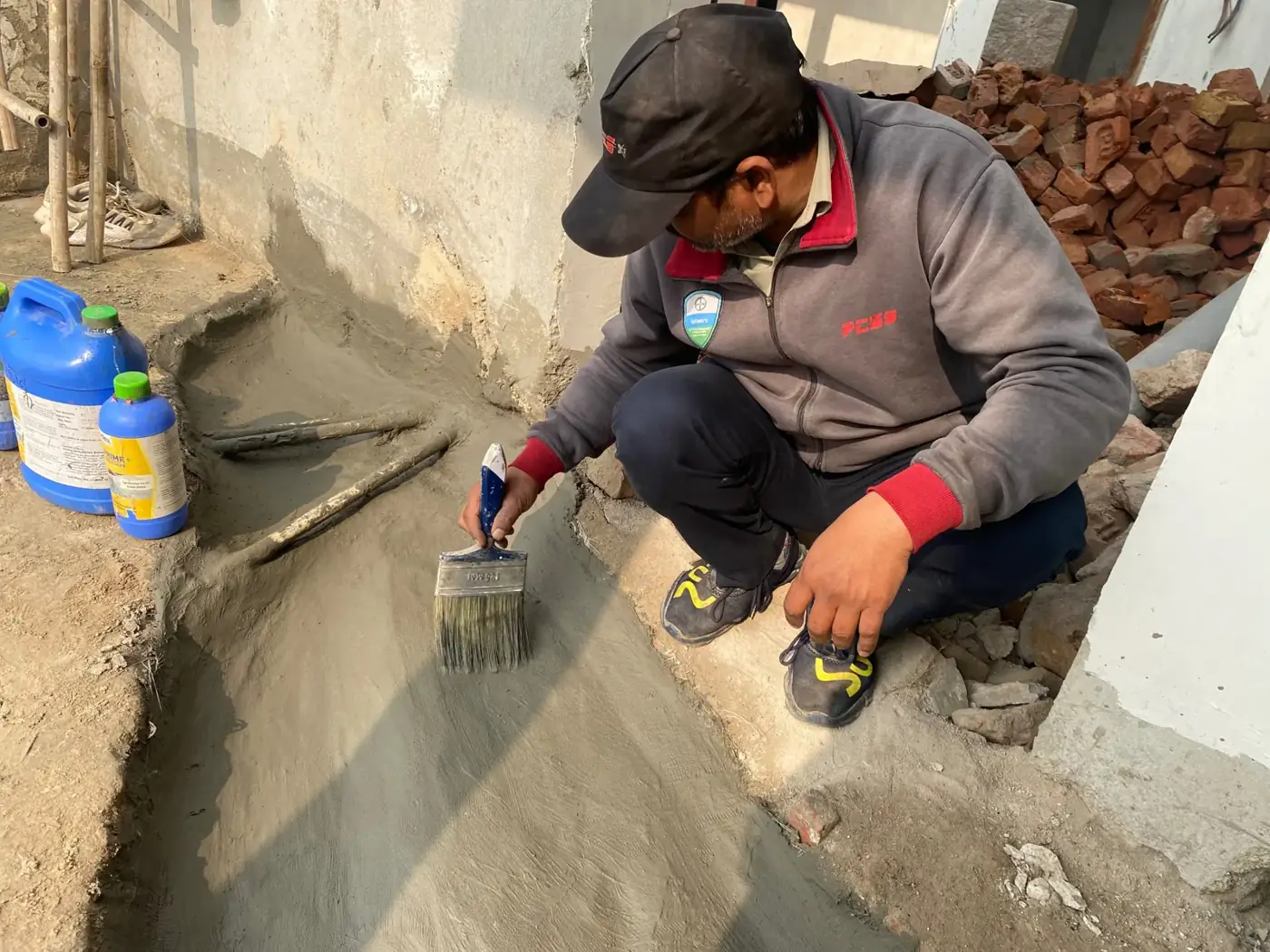 PCES applicator brushing a waterproofing coat on site